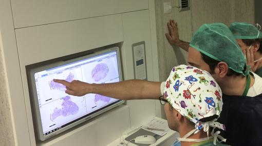 Técnicos revisan un monitor por un tratamiento de cáncer de piel