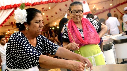 Unas gitanas hacen buñuelos en el recinto de la Feria de abril de Sevilla