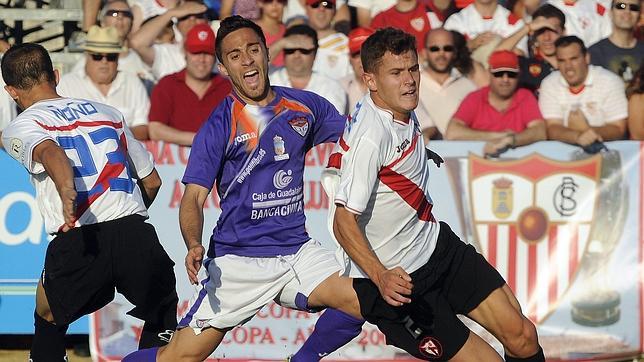 El sevillista Morales arranca con el bal�n y deja atr�s a un jugador alcarre�o