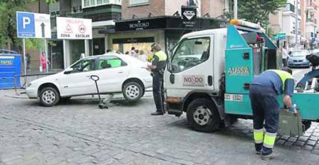 Una gra municipal retira un coche mal aparcado