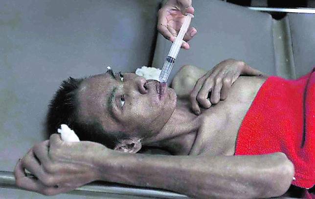 Un enfermo terminal de sida recibe tratamiento en un templo budista