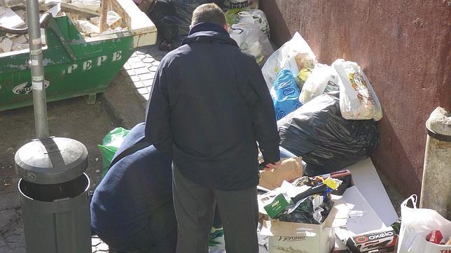 Un inspector abre bolsas de basuras el pasado da 10 en la calle Carlos Caal y examina documentos 