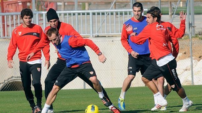 Escud�, ahora titular, pugna por un bal�n durante un entrenamiento con Rakitic