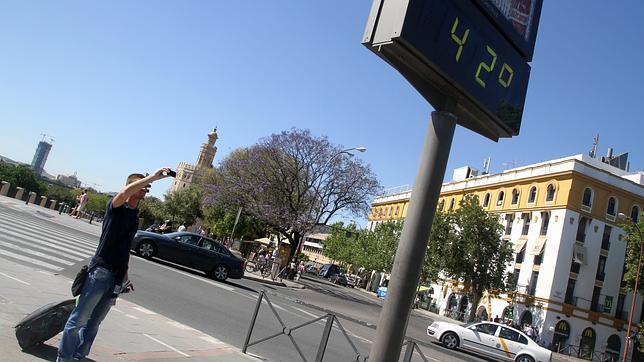 Un turista fotograf�a un term�metro en Sevilla, el cual refleja las altas temperaturas que soporta la ciudad en las �ltimas horas