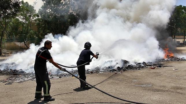 Los bomberos, sofocan las llamas del incendio en el Charco de la Pava