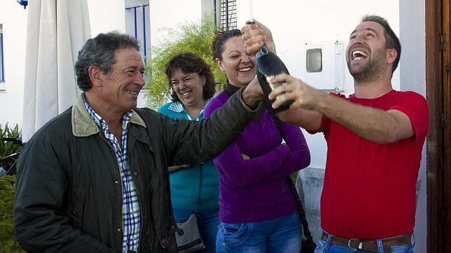 El vecino de Villarrasa (Huelva), Pedro Medina (i), celebra con su hijo el Gordo de la Loter�a de Navidad