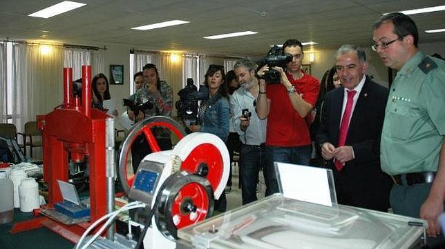 El subdelegado del Gobierno, Santiago P�rez (centro) observa la m�quina incautada a la banda. ABC