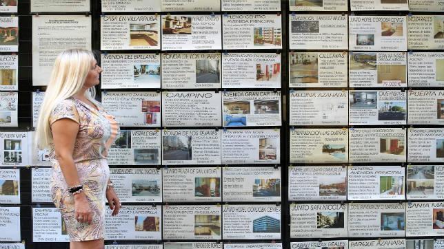 Mar�a Fern�ndez, encargada de la inmobiliaria Chirinos, observa el escaparate lleno de ofertas de pisos.