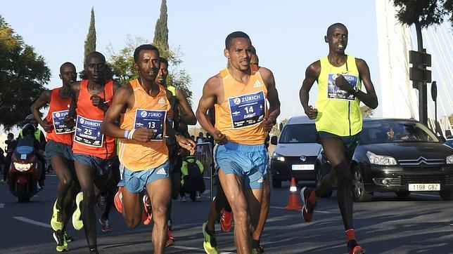 Varios atletas corren por los adelaos del puente del Alamillo