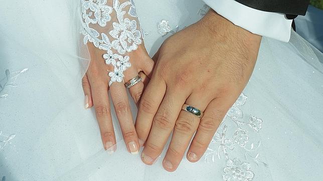 Una pareja de reci�n casados entrelaza sus manos