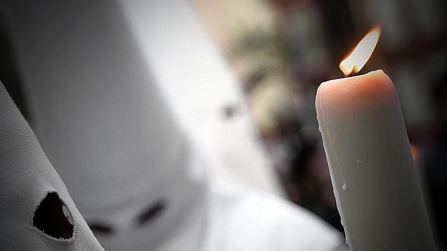 Imagen de un cirio encendido en el cortejo de una hermandad