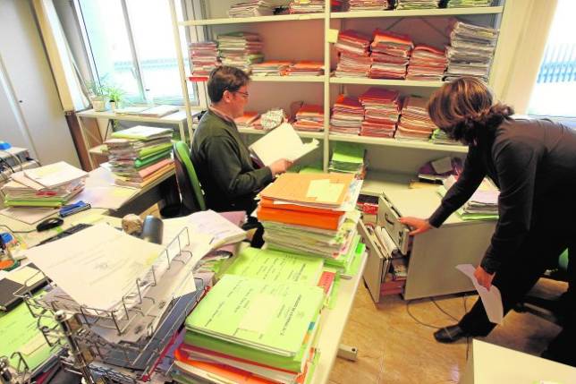 Dos funcionarios de un juzgado cordob�s ordenan expedientes en las estanter�as 