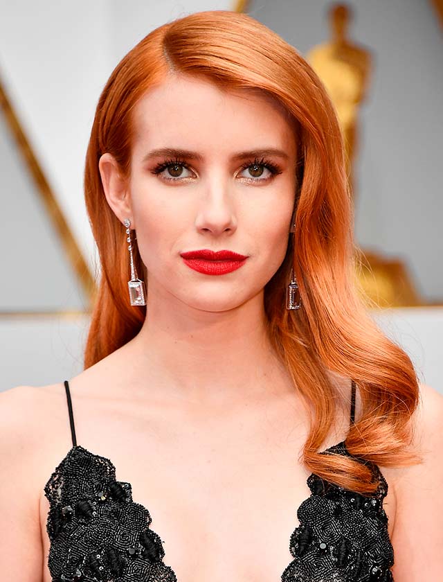 Emma Roberts, con ondas Hollywood, raya a un lado y labial rojo (AFP)