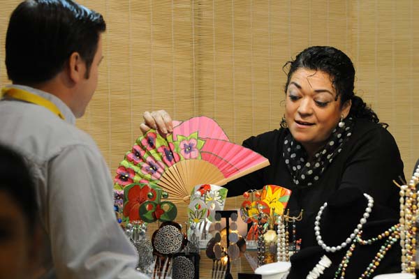 En la imagen, una dependienta muestra una amplia gama de abanicos y otros complementos de vestir