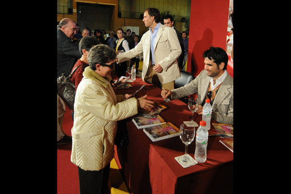 Julio Aparicio, de pie, y Salvador Vega, sentado, firmando autgrafos