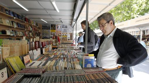 Un hombre consulta los títulos en un stand de la Feria del Libro