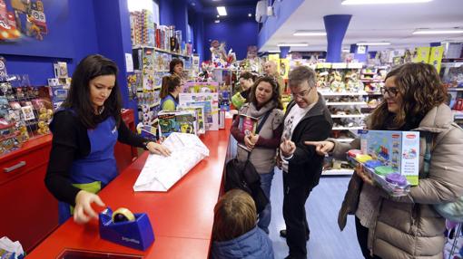Padres comprando los regalos esta Navidad en la tienda de Juguettos de Conde de Robledo