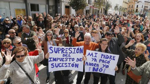 Un nutrido grupo de personas protesta en la calle Capitulares