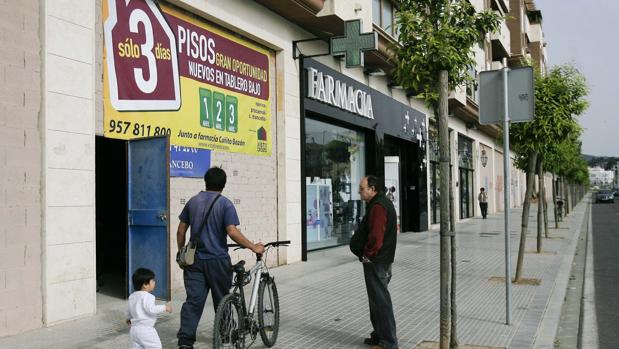 Un hombre pasa delante de un anuncio promocionando la venta de pisos nuevos en Tablero Bajo