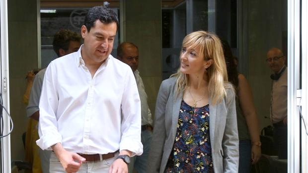 Juanma Moreno, líder del PP andaluz, junto a Carmen Castilla, la secretaria general de UGT este viernes en la sede regional del PP