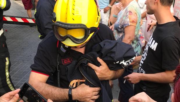 Un bombero con el águila rescatada envuelta en una chaqueta