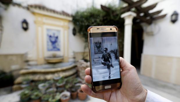 Una persona muestra la fotografía de Manolete en el mismo patio de la vivienda