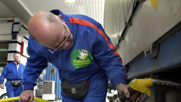 Un empleado llena el depÃ³sito de un camiÃ³n de transporte de mercancias agrÃ­colas