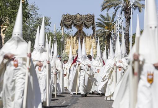 La Virgen de la Merced avanza escoltada por los nazarenos de su hermandad