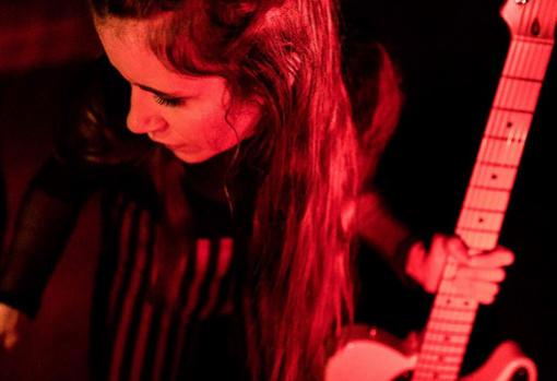 Carmen Boza sosteniendo su guitarra