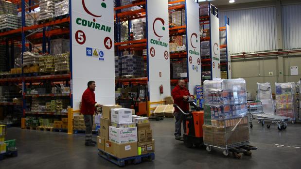 Trabajadores mueven palets en un almacén de la cadena granadina Covirán