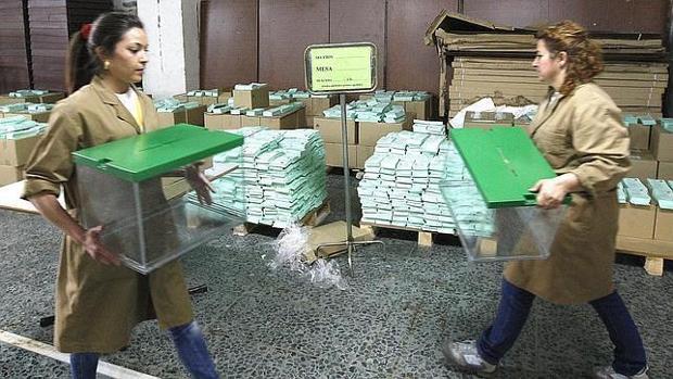 Dos mujeres portando urnas electorales