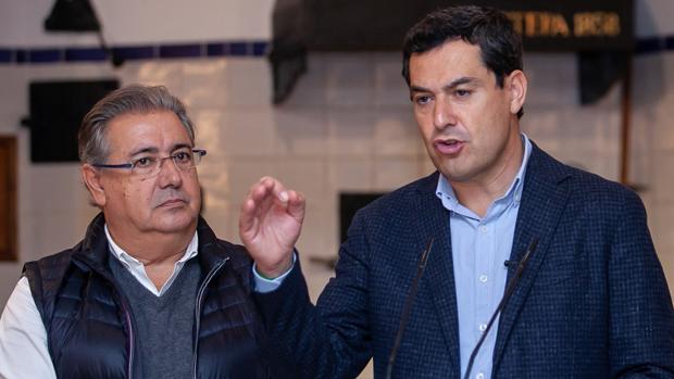 El candidato número uno del PP por Sevilla en las elecciones en Andalucía, Juan Ignacio Zoido, junto al candidato del PP a la Junta de Andalucía, Juanma Moreno, durante su visita este miércoles a una fábrica de polvorones en Estepa