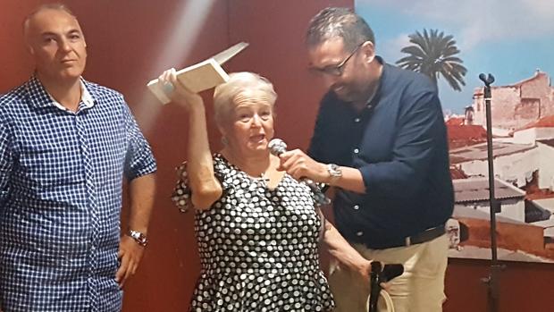 Florencia Soyo recibe el galardón de manos del presidente de la caseta «Por Soleá», Rafa Ruiz