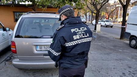 Un agente de la Policía Local de Sevilla sanciona a un vehículo